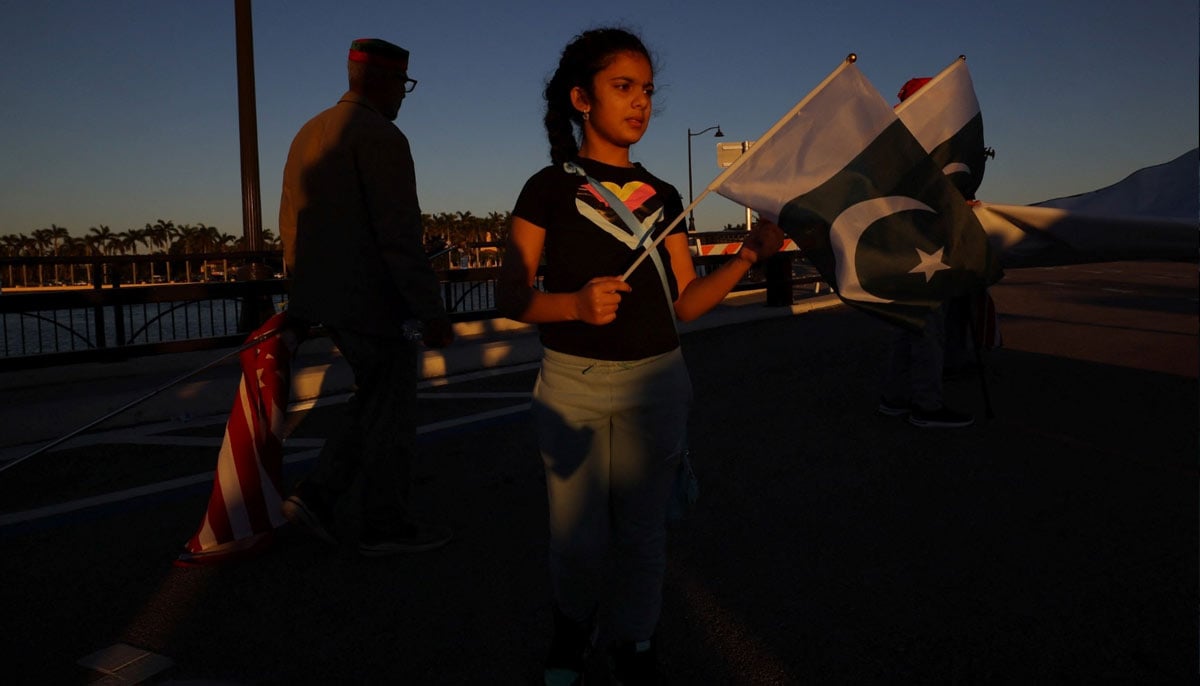 A young supporter of Imran Khan holding Pakistani flags while participating in the rally in Palm Beach, Florida, November 23, 2024. — Reuters