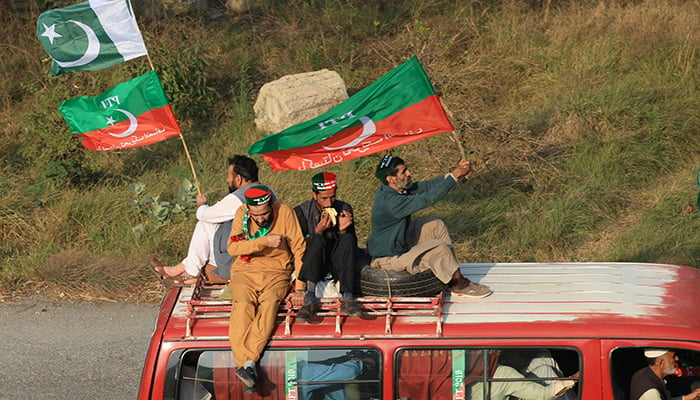 Supporters of PTI founder Imran Khan sit atop a vehicle as they head towards Islamabad, during an anti-government rally, in Peshawar, November 24, 2024. — Reuters