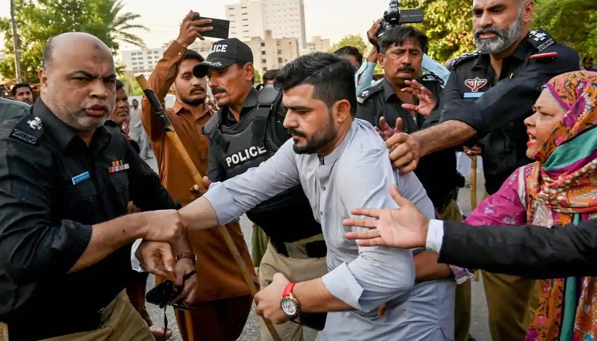 Police personnel detain PTI supporters whilst they protest to demand the release of former prime minister Imran Khan, in Karachi on October 18, 2024. — AFP