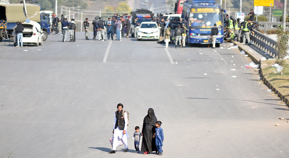 Family walks on Faizabad Bridge on the way during roads blocked and markets closed in the twin city ahead of PTI protest in the Federal Capital on November 25, 2024. — Online