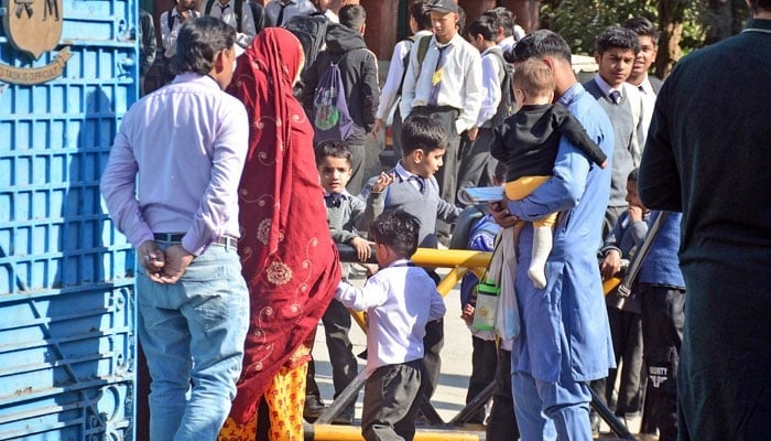 Students going back to home after attend their class at a school in Punjab. — Online/File