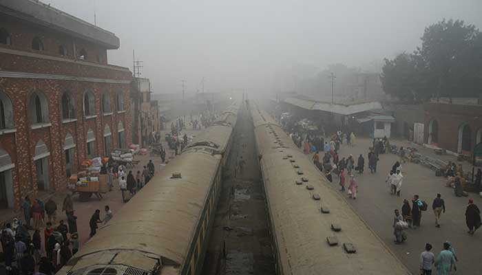 People walk to board trains amid smog and air pollution at a railway station in Lahore, November 14, 2024. — Reuters