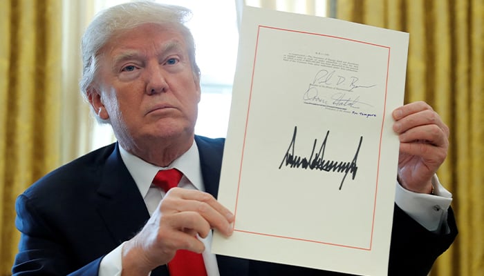 Donald Trump displays his signature after signing the $1.5 trillion tax overhaul plan in the Oval Office of the White House in Washington, U.S., December 22, 2017. — Reuters