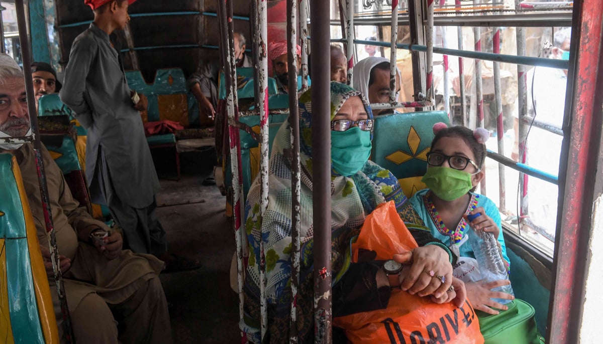 Women are seated in a public bus in Karachi. — AFP