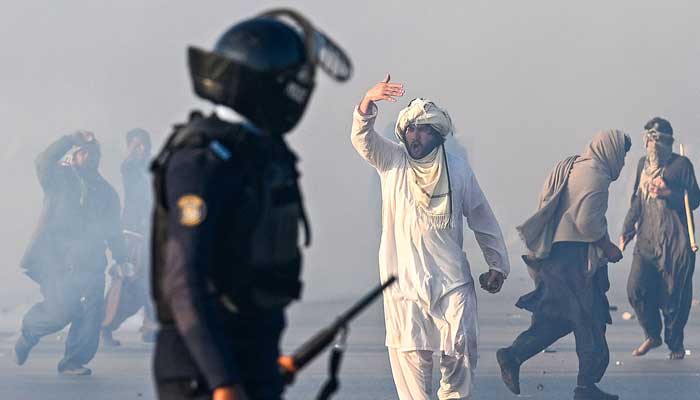 A  PTI supporter gestures after tear gas was fired by the police to disperse the crowd during the protest in Islamabad on November 26, 2024.  — AFP