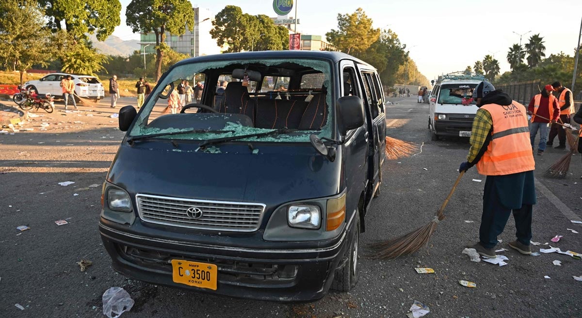 Municipal workers clean the street leading to Red Zone area next to damaged vehicles after an overnight security forces operation against the supporters of jailed former prime minister Imran Khan´s Pakistan Tehreek-e-Insaf (PTI) party in Islamabad on November 27, 2024. — Reuters