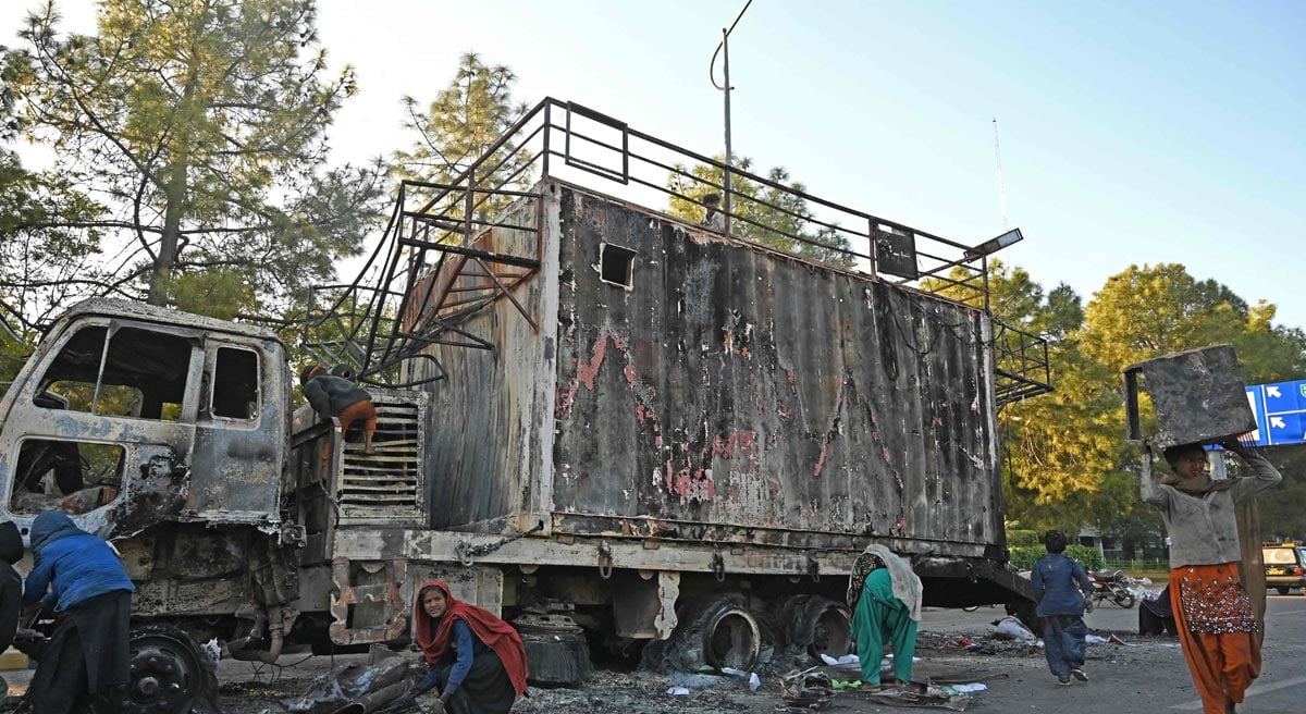 Ragpickers collect scraps from a burnout rally truck used by Bushra Bibi, the wife of Pakistan´s former prime minister Imran Khan, near the red zone area after a protest to demand Khan´s release, in Islamabad on November 27, 2024. — Reuters