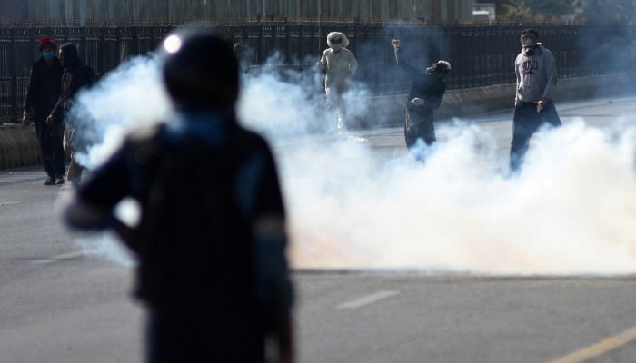 A supporter of the PTI throws an object towards security force personnel during a protest rally in Islamabad on November 26, 2024. —Reuters