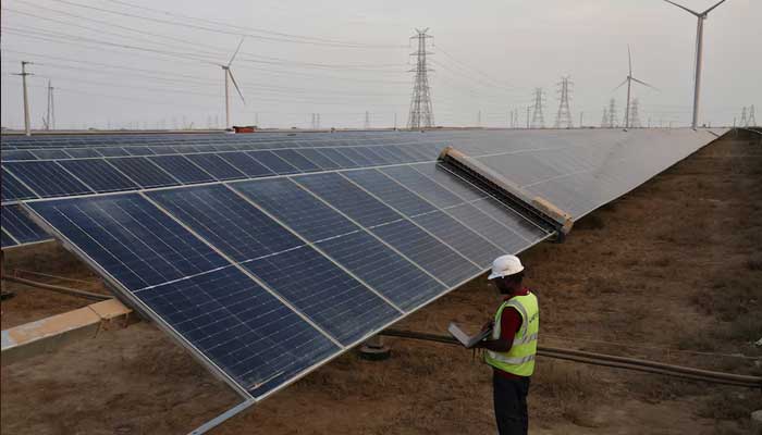 A technician checks the movement of an Automated cleaning brush installed over solar panels in Khavda Renewable Energy Park of Adani Green Energy Ltd in Khavda, India on  April 12, 2024. — Reuters