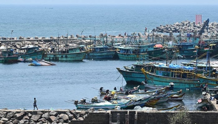 A fisherman shifts a fishing boat at Kasimedu fishing harbour during a 61-day trawling ban in Chennai on April 25, 2023. — Reuters