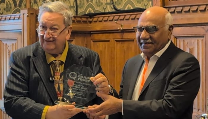 Pakistani philanthropist Dr Amjad Saqib (right) poses as he receives the award. — Reporter