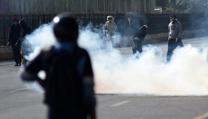 A PTI supporter throws an object towards security force personnel during a protest rally demanding the party founder Imran Khans release in Islamabad, November 26, 2024. — Reuters