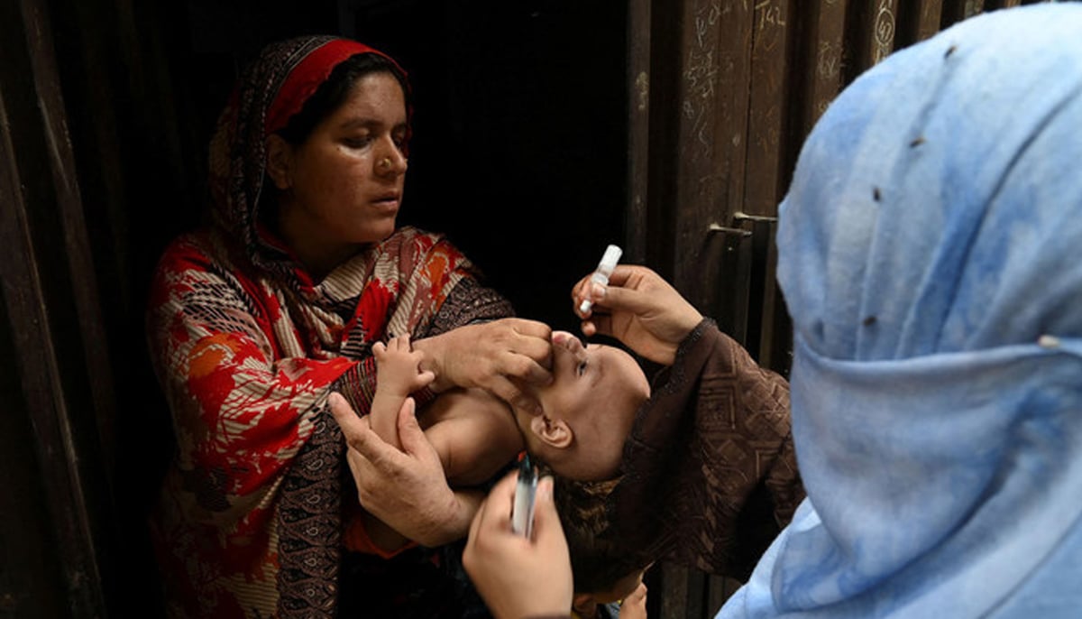 A health worker administers polio vaccine drops to a child during a polio vaccination campaign at a slum area in Lahore, Pakistan, on August 2, 2021. — AFP