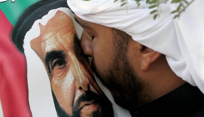 An Emirati man kisses the picture of Sheikh Zayed bin Sultan al-Nahyan during the Sheikhs funeral in Abu Dhabi on November 3, 2004. —AFP