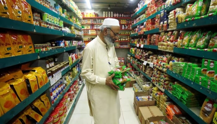 A man shops for grocery items at a store in Peshawar on April 27, 2018. — Reuters