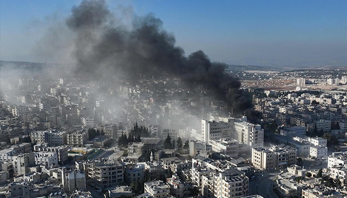 An aerial picture shows smoke rising from the site of an airstrike that targeted Syria´s rebel-held northern city of Idlib on December 2, 2024.   — AFP