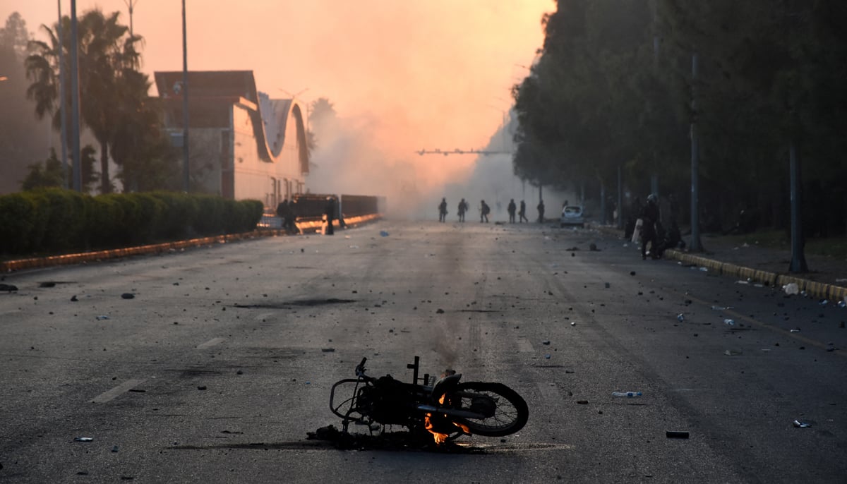 A motorcycle burns during a protest rally by PTI supporters in Islamabad, November 26, 2024. — Reuters