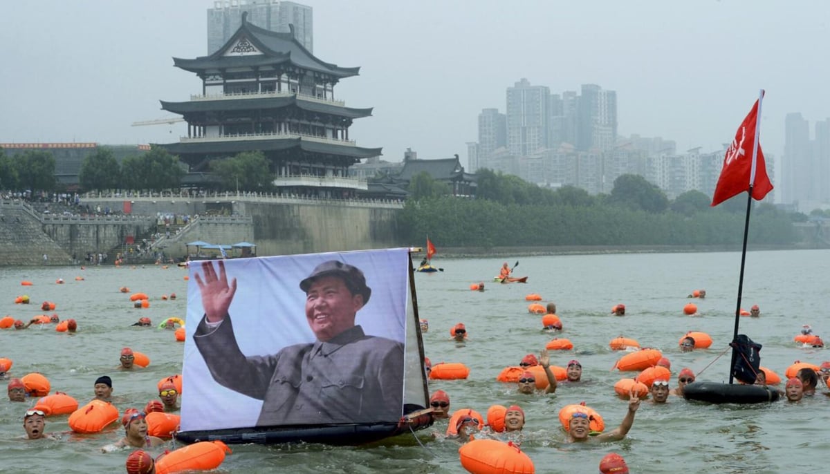 Participants wave as they swim with a portrait of late Chinese chairman Mao Zedong in the Xiangjiang river, a large branch of the Yangtze River, in Changsha, Hunan province, China, July 18, 2015. — Reuters