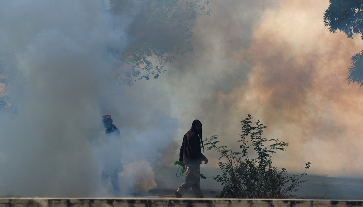 Supporters of the former prime minister Imran Khans party Pakistan Tehreek-e-Insaf (PTI) walk amid tear gas smoke fired by security forces during an anti-government rally in Islamabad, November 26, 2024. — Reuters