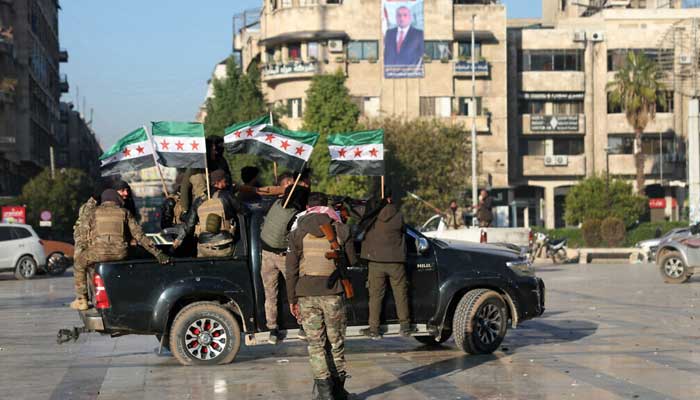 Anti-government fighters wave opposition flags in Syrias northern city of Aleppo on November 30, 2024. — AFP