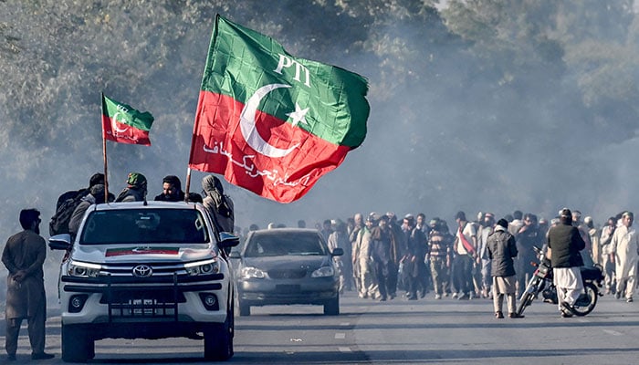 Supporters of jailed PTI founder Imran Khan march towards Islamabad after clearing shipping containers placed by authorities during a demonstration demanding former prime ministers release, in Punjabs Hasan Abdal on November 25, 2024. — AFP