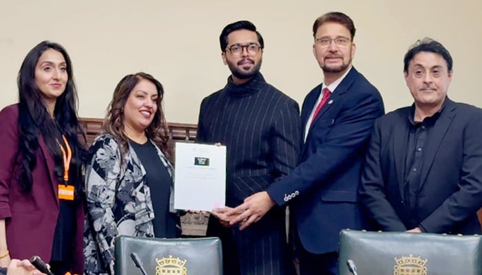 Fahad Mustfa (centre right) receives awards at the House of Commons, by Multicultural UK. — Reporter