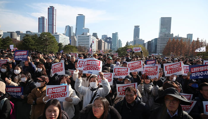 People hold placards at a rally to condemn South Korean President’s surprise declaration of the martial law last night and to call for his resignation, at the national assembly in Seoul, South Korea, December 4, 2024. — Reuters