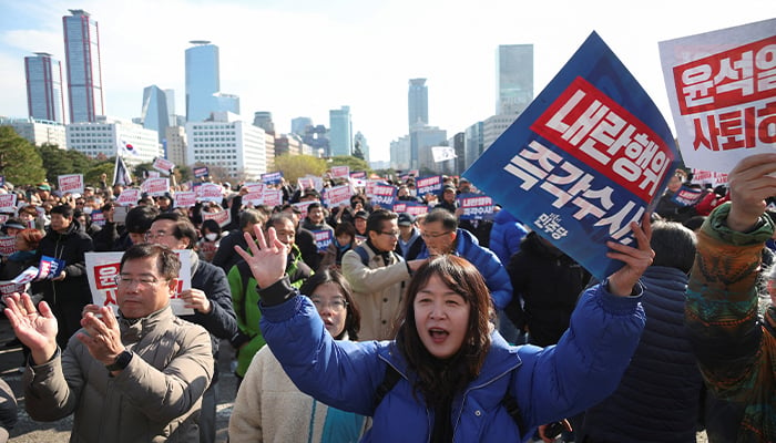 People hold placards at a rally to condemn South Korean President’s surprise declaration of the martial law last night and to call for his resignation, at the national assembly in Seoul, South Korea, December 4, 2024. — Reuters