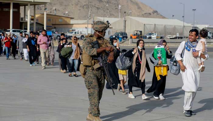 A US Marine assigned to 24th Marine Expeditionary Unit escorts evacuees during an evacuation at Hamid Karzai International Airport, Afghanistan, August 18, 2021. — Reuters