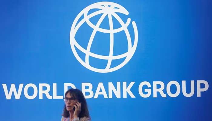 A participant stands near a logo of World Bank at the International Monetary Fund - World Bank Annual Meeting 2018 in Nusa Dua, Bali, Indonesia, October 12, 2018. — Reuters