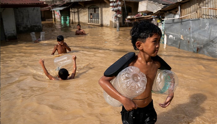 Children play along a flooded street following super typhoon Man-Yi, in Cabanatuan, Nueva Ecija, Philippines, November 18, 2024. — Reuters