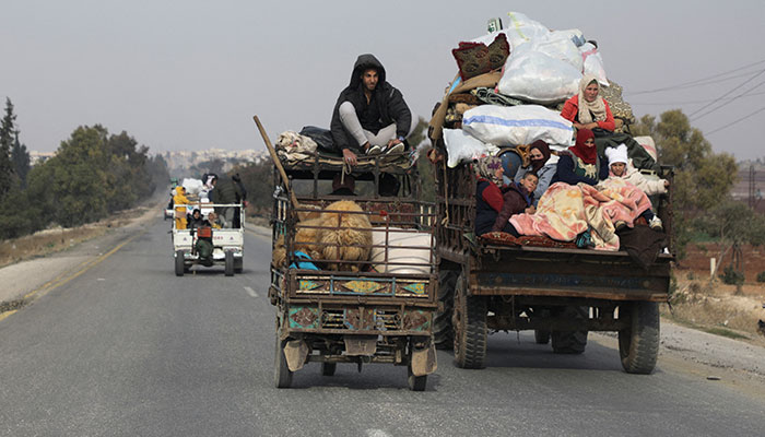 People ride on vehicle with belongings in Hama, after rebels led by HTS have sought to capitalize on their swift takeover of Aleppo in the north and Hama in west-central Syria by pressing onwards to Homs, in Hama, Syria December 6, 2024. — Reuters