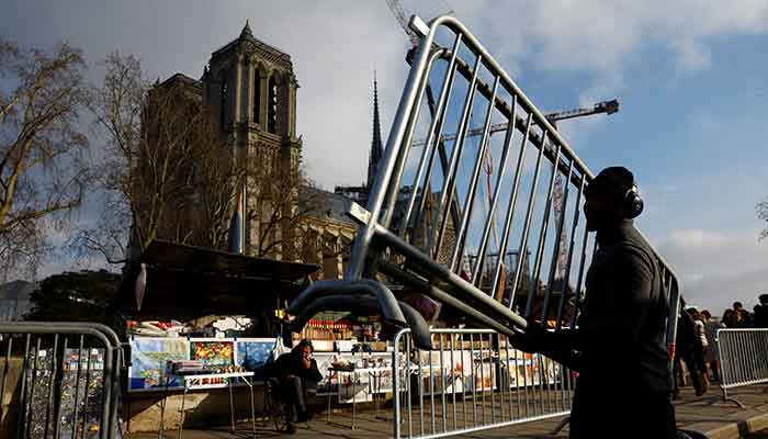 Ein Mitarbeiter installiert Absperrungen, um vor den Ständen der Buchhändler am Ufer der Seine im Vorfeld der Wiedereröffnungszeremonien der Kathedrale Notre-Dame de Paris in Frankreich am 4. Dezember 2024 einen Sicherheitsbereich einzurichten. – Reuters