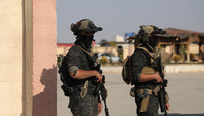 Members of the Kurdish-led Syrian Democratic Forces (SDF) stand together as they hold their weapons in Hasaka, Syria December 6, 2024. — Reuters