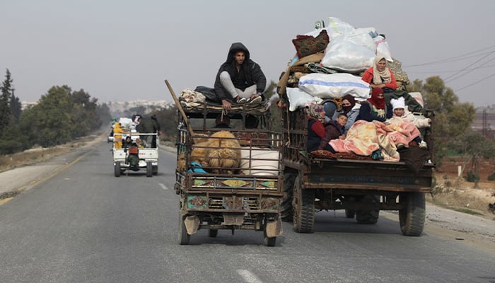 Menschen fahren in Fahrzeugen mit Habseligkeiten in Hama, nachdem von HTS angeführte Rebellen versucht haben, aus ihrer schnellen Übernahme von Aleppo im Norden und Hama im Westen Zentralsyriens Kapital zu schlagen, indem sie weiter nach Homs in Hama, Syrien, vordrangen, 6. Dezember 2024. — Reuters