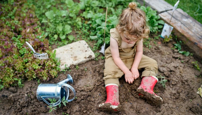 A representational image shows a child playing in the dirt. — Unsplash