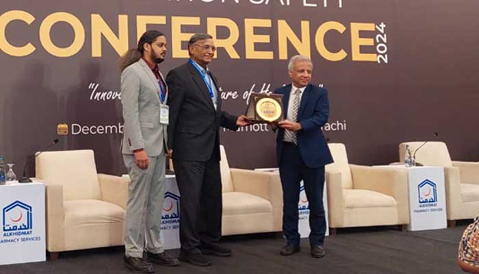 Participants pose with a shield at the Medication Safety Conference in Karachi. — Reporter