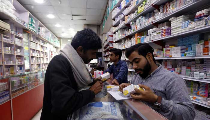 A customer buys medicine from a medical supply store in Karachi on February 9, 2023. — Reuters