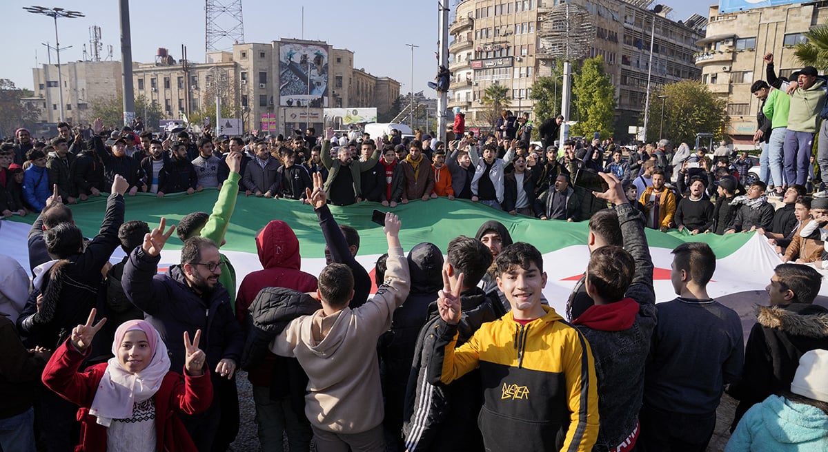 Die Menschen halten die Flagge der syrischen Opposition hoch, während sie feiern, nachdem das syrische Armeekommando am Sonntag in Aleppo, Syrien, am 8. Dezember 2024 die Beamten über das Ende der 24-jährigen autoritären Herrschaft von Präsident Bashar al-Assad informiert hatte. – Reuters