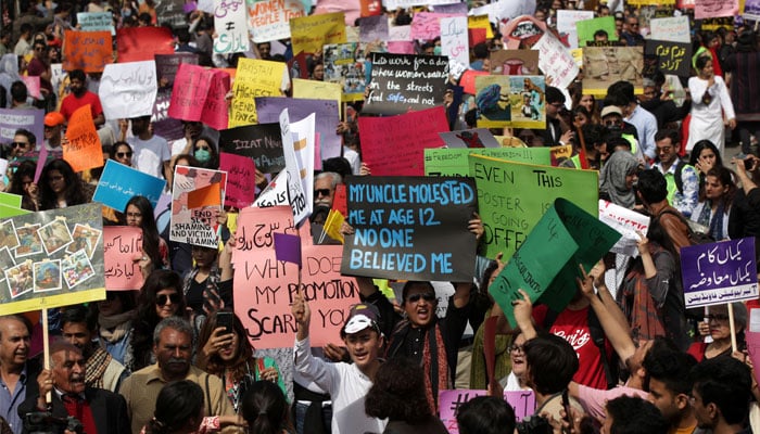 Women and men carry signs as they take part in an Aurat March, or Womens March in Lahore, March 8, 2020. — Reuters