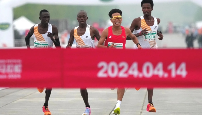 Chinese runner He Jie (second right), Ethiopian Dejene Hailu Bikila (right) and Kenyans Robert Keter and Willy Mnangat at the finish line of the Beijing Half Marathon on April 14, 2024. — Reuters