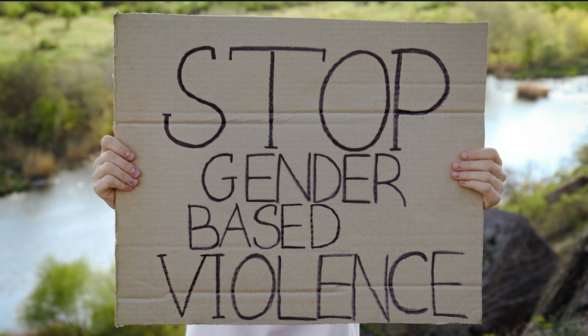 A representational image of a woman holding a placard that reads Stop Gender Based Violence. — Canva