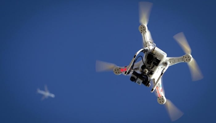 An airplane flies over a drone during the Polar Bear Plunge on Coney Island in New York, US, January 1, 2015. — Reuters