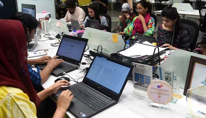 People work at their laptops at the National Incubation Centre (NIC), a startup incubator, in Lahore. — AFP/File