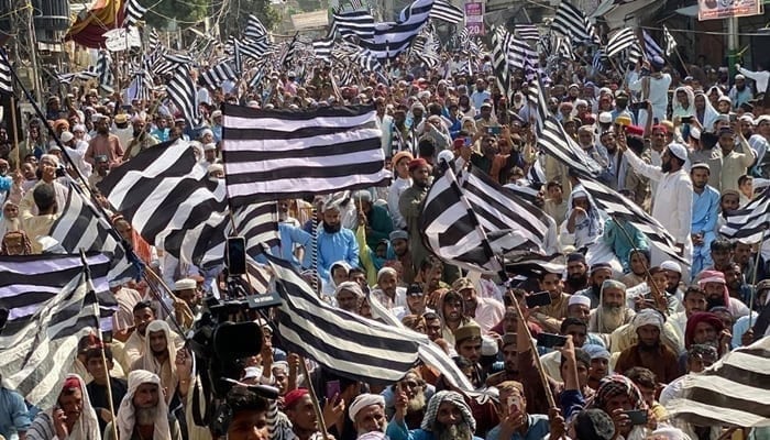 JUI-F supporters hold flags during a party rally in this image released on October 26, 2023. — Facebook/Jamiat Ulama-e-Islam Pakistan