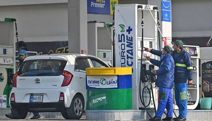 Employees at a fuel station attend to their customers in Islamabad, Pakistan, on February 16, 2022. — AFP/File