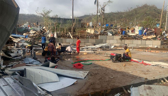 A photo taken on December 15, 2024 shows residents sittingamong piles of debris of metal sheets and wood after homes were destroyed by the cyclone Chido that hit France´s Indian Ocean territory of Mayotte.— AFP