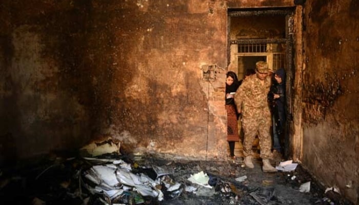 Shoes, uniforms and geometry sets are scattered around at the APS Peshawar. —AFP/File