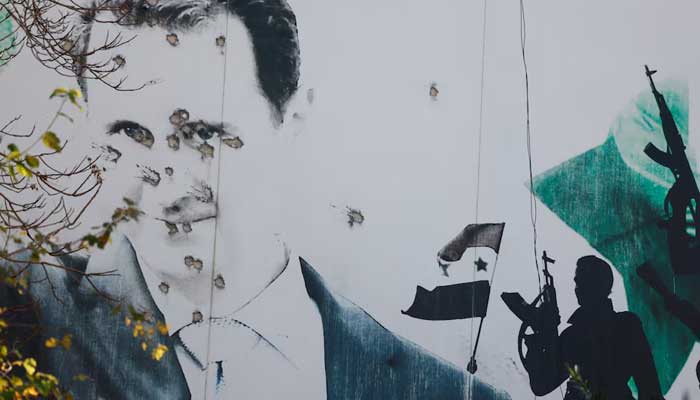 A billboard with a picture of Syrias Bashar al-Assad shows damage by bullet holes, after the ousting of Syrias Bashar al-Assad, in Damascus, Syria, December 16, 2024. — Reuters