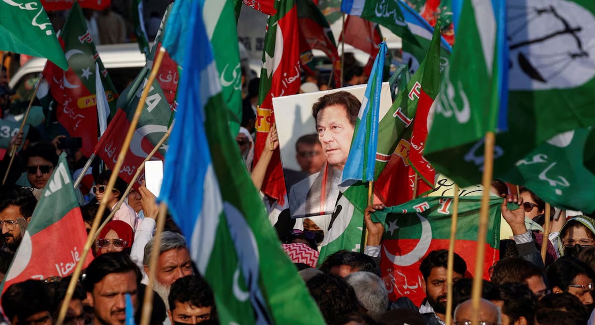 A portrait of the former prime minister Imran Khan is seen amid flags of Pakistan Tehreek-e-Insaf (PTI) and the Jamaat-e-Islami (JI) as supporters attend a joint protest demanding free and fair results of the elections, outside the provincial election commission of Pakistan (ECP)in Karachi on February 10, 2024. — Reuters